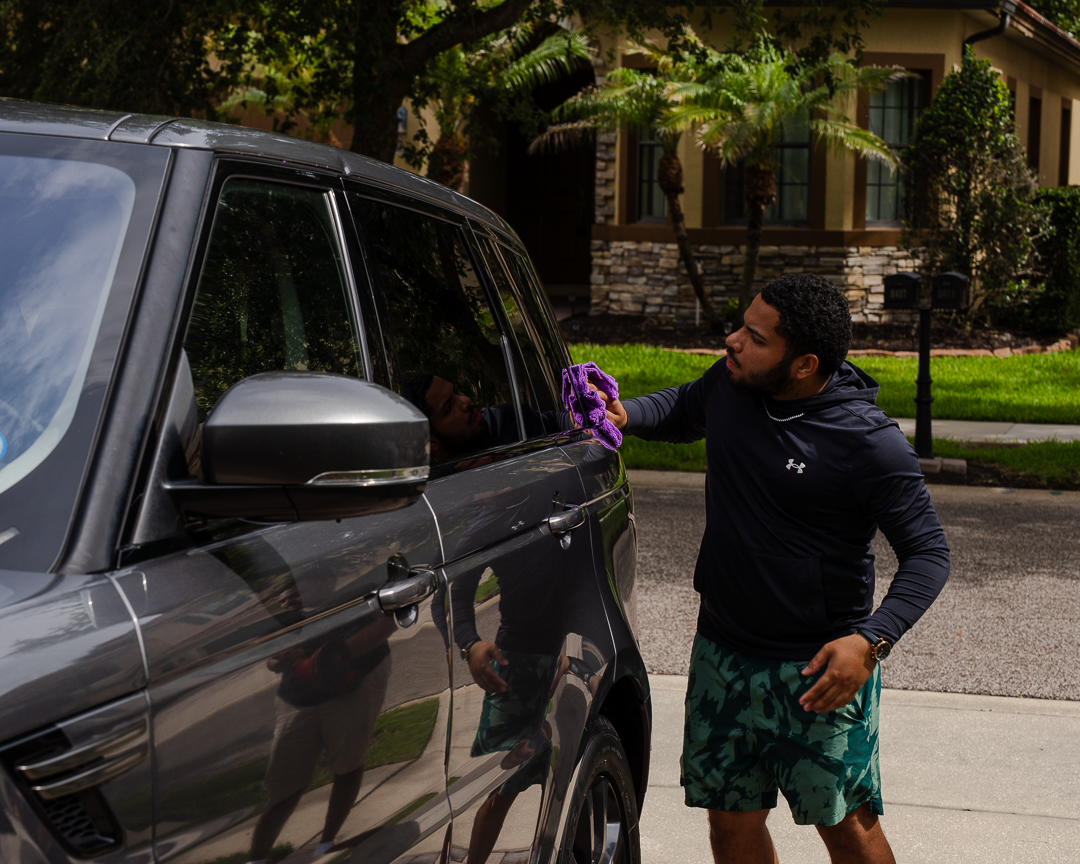 JDM Wash detailer hand-drying a Range Rover in a Kissimmee driveway