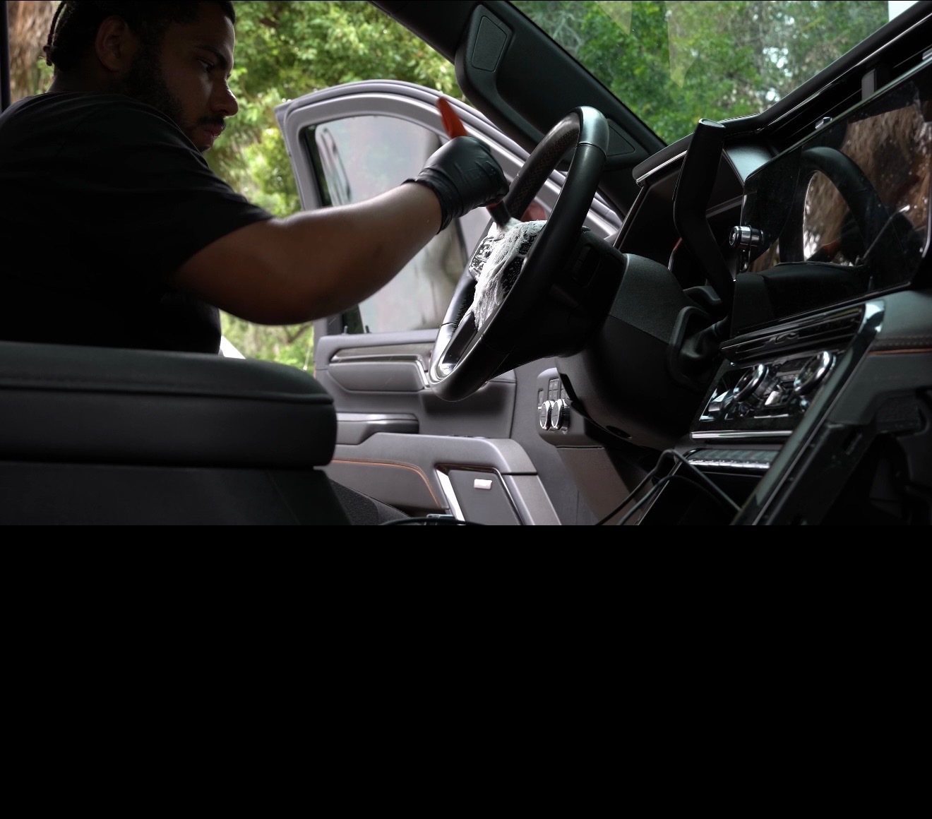 JDM Wash detailer wiping a truck steering wheel with gloves on